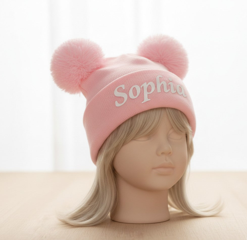 Pink personalised double pom pom baby beanie with name Sophia on mannequin head