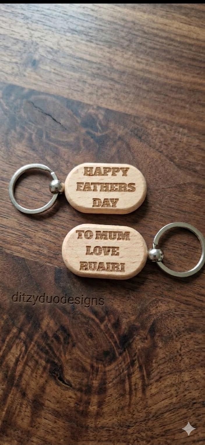 Two personalised wooden keyrings engraved with Happy Fathers Day and To Mum Love Ruari